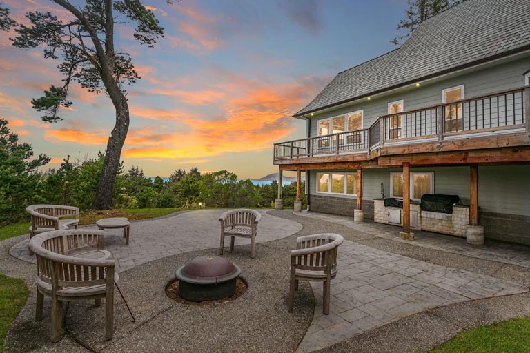 A vacation rental home in Gold Beach, Oregon with ocean views, a wraparound balcony and firepit area.
