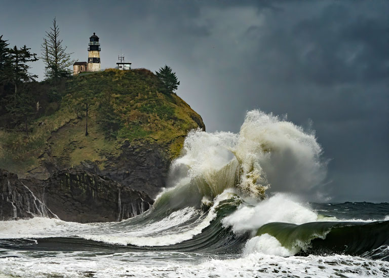 Cape Disappointment State Park Lighthouse sits high on a cliff in southwest Washington as huge waves crash below