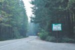 Welcome to Oregon highway sign on a forest road