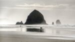 People walking on the beach in front of Haystack Rock on the Oregon Coast