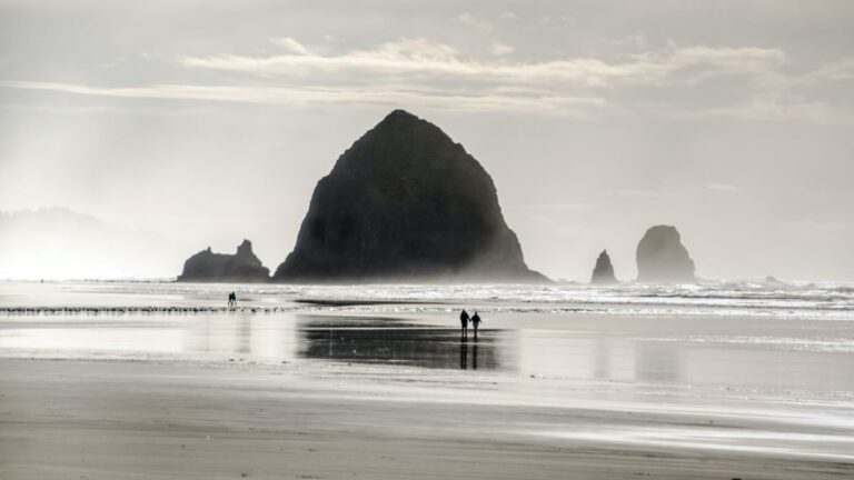 People walking on the beach in front of Haystack Rock on the Oregon Coast