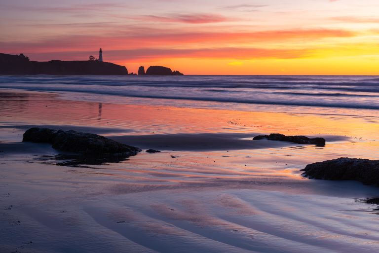Agate Beach in Newport Oregon with a view of Yaquina Bay Lighthouse at sunset on the Oregon Coast