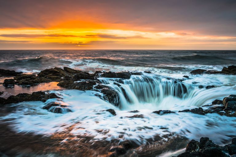 Thor's Well Oregon Coast at sunset appears to be a drainpipe in the Pacific Ocean.