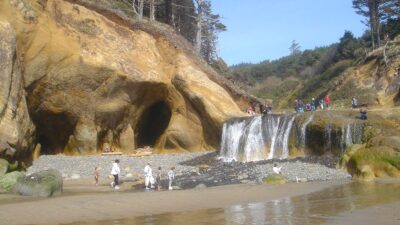 Hug Point waterfall near Cannon Beach on the Oregon Coast with beach coves and caves at low tide