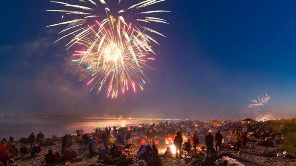 Families have a bonfire on the beach and watch fireworks on 4th of July in Lincoln City, Oregon