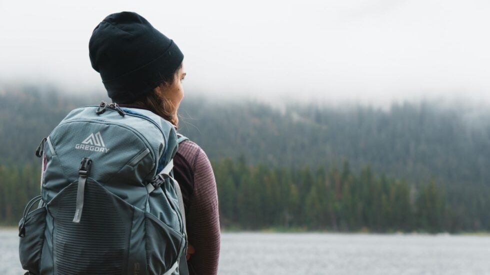 A woman wears a waterproof backpack on the Oregon Coast