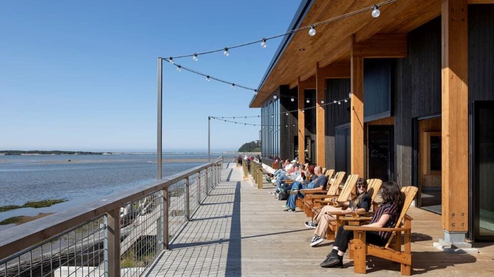 Pelican Brewing Siletz Bay restaurant and brewery with a view of the water and balcony seating.